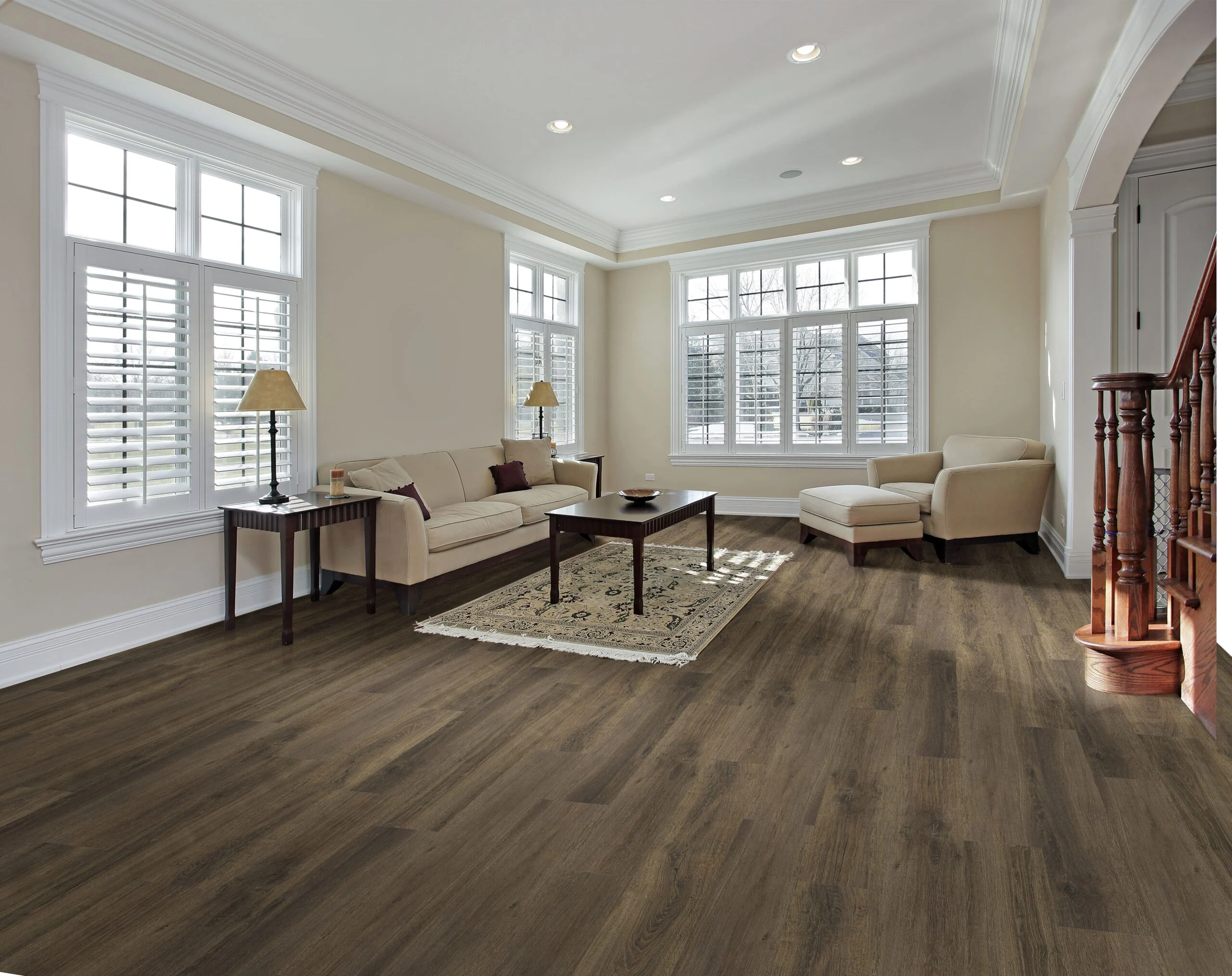 A modern living room floor with wide plank SPC flooring in a muted oak tone, textured with a handscraped grain finish, with sunlight streaming in.
